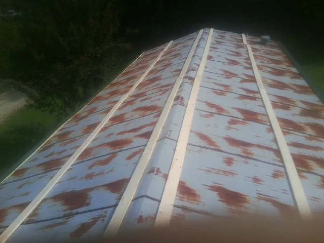 Rusted metal roof panels with new wood purlins before replacement — Storm Damage Roof Repair in Goffstown by Roofing Brothers